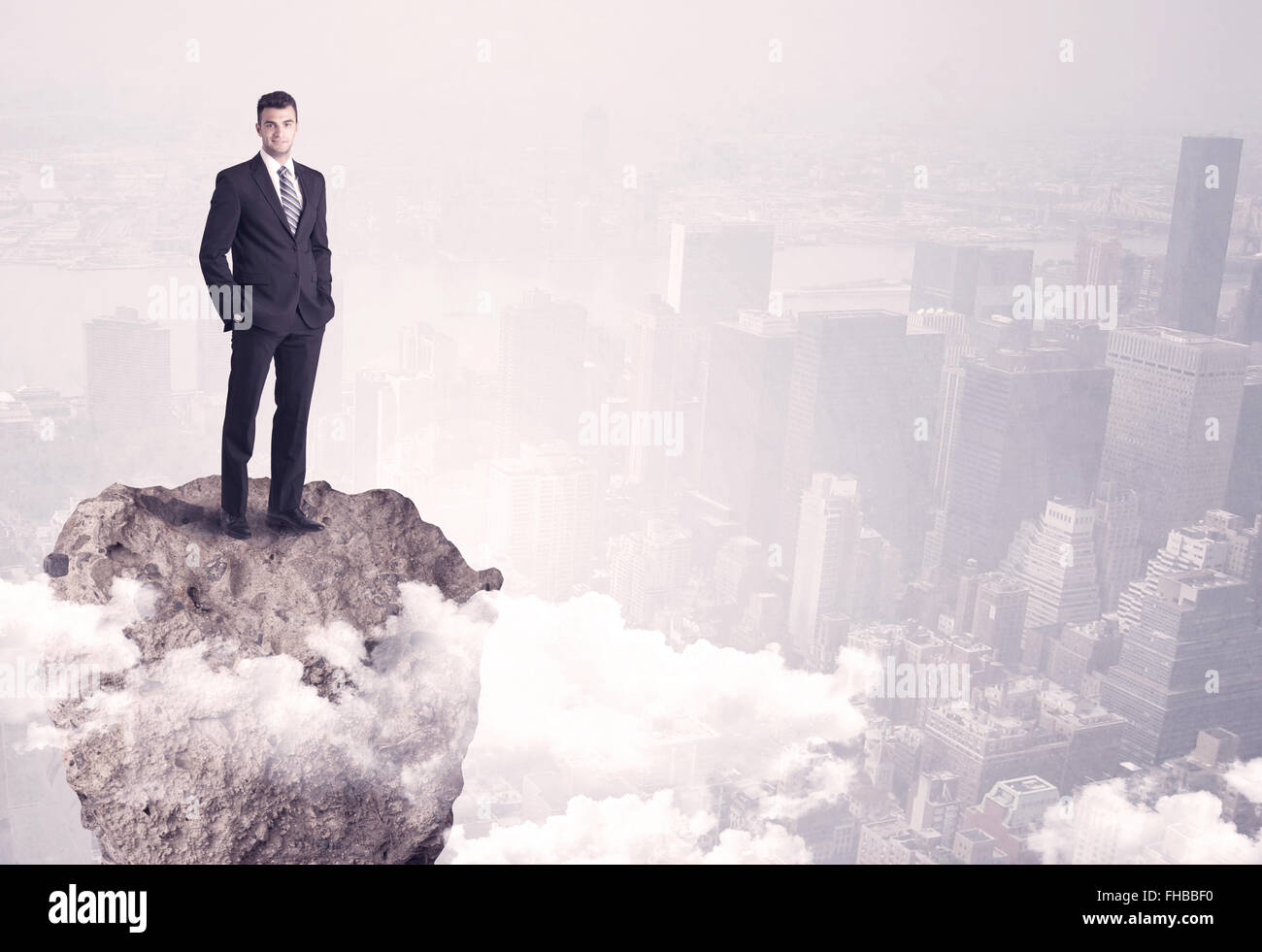 Vincitore business persona in piedi sulla roccia Foto Stock