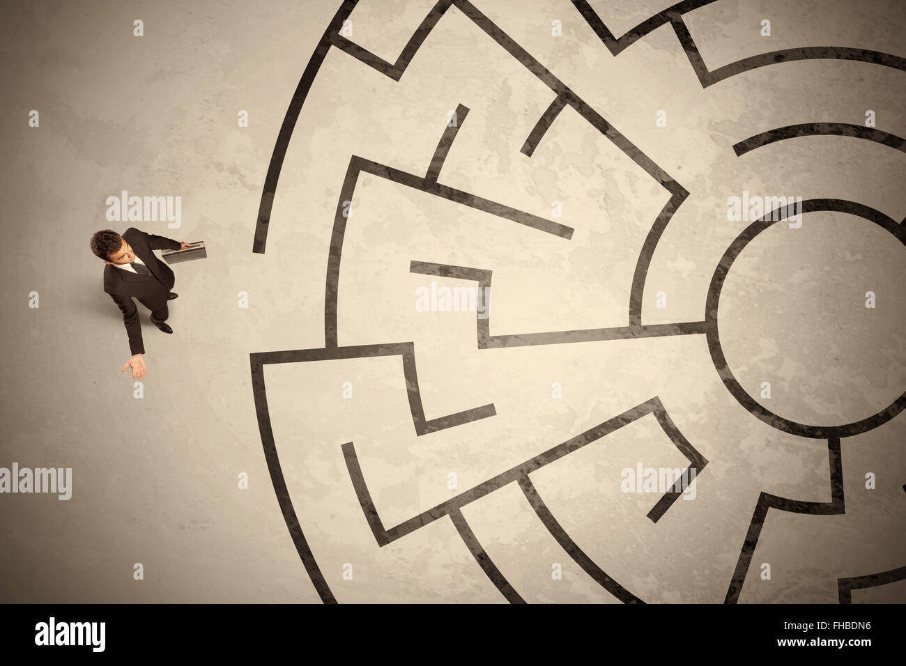 Perso il business man cercando un modo nel labirinto circolare Foto Stock