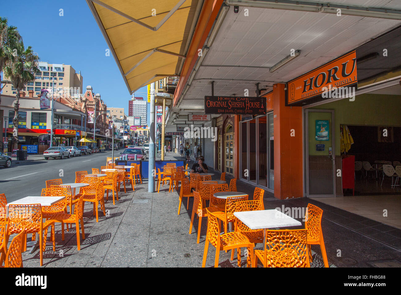 Cafe con posti a sedere di colore arancione sul marciapiede, vista attraverso Hindley Street ovest-est Foto Stock