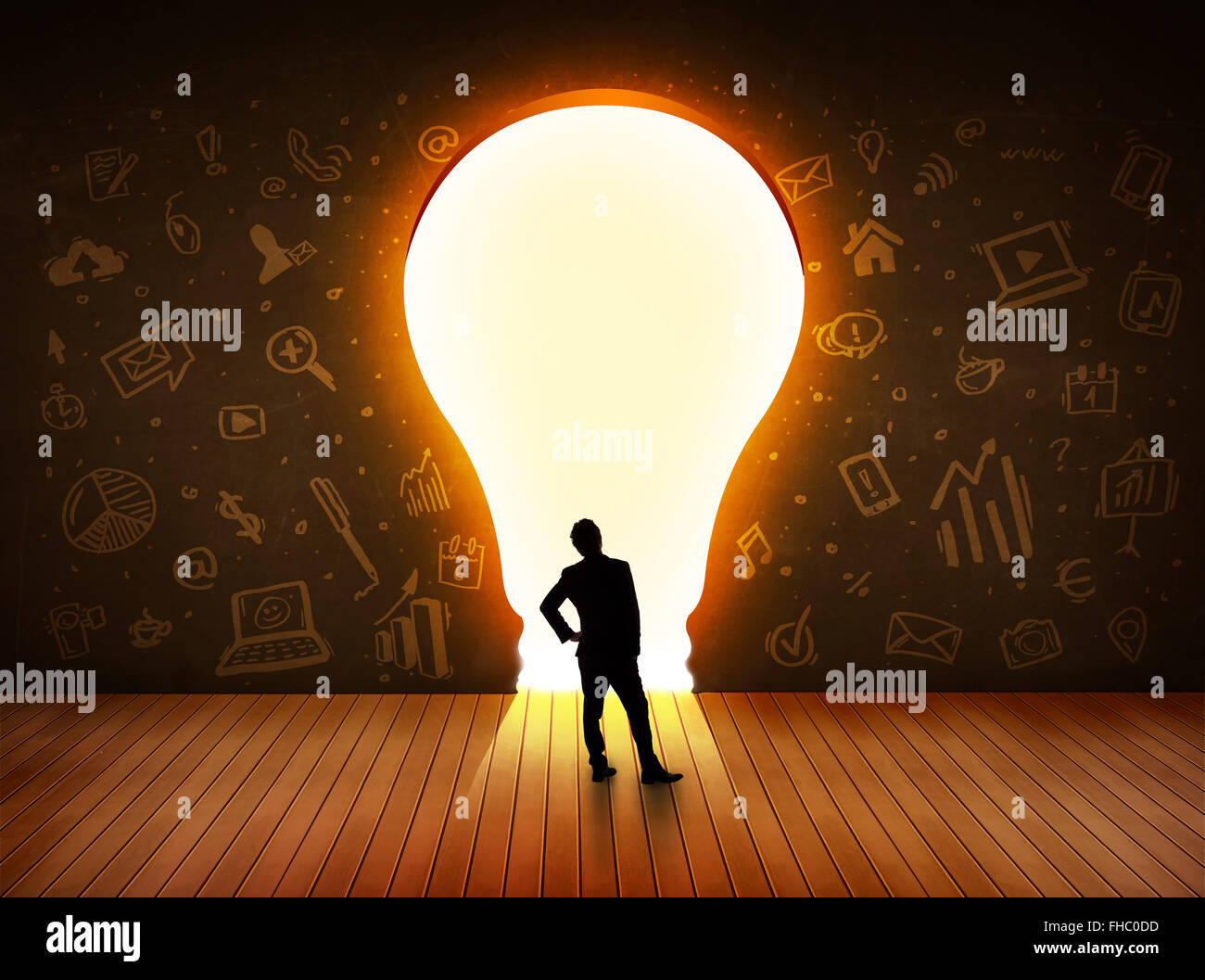 Business man guardando alla luce brillante lampadina nella parete Foto Stock