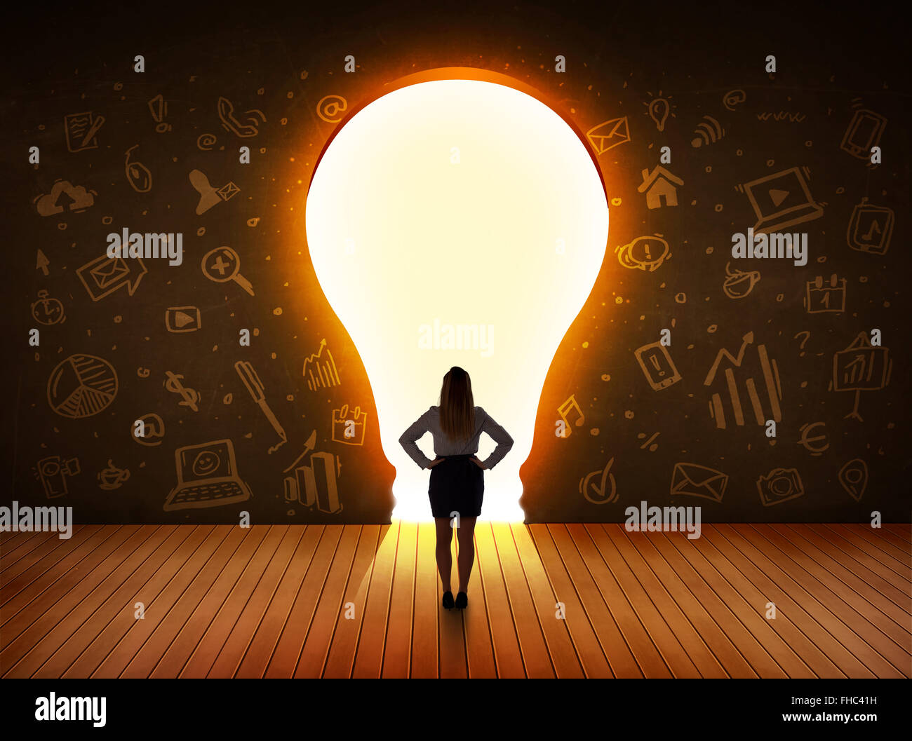 Business donna che guarda la luce brillante lampadina nella parete Foto Stock