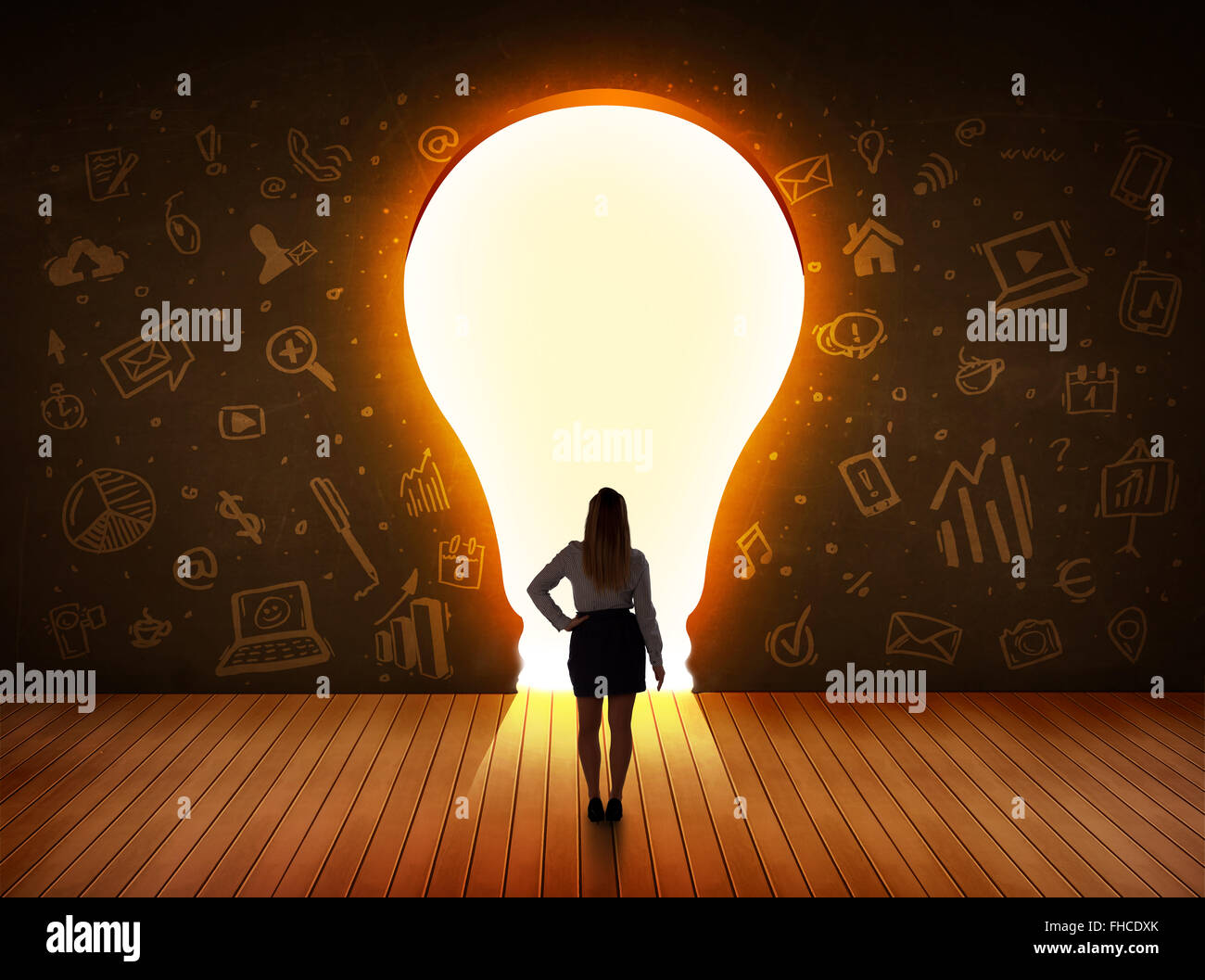 Business donna che guarda la luce brillante lampadina nella parete Foto Stock