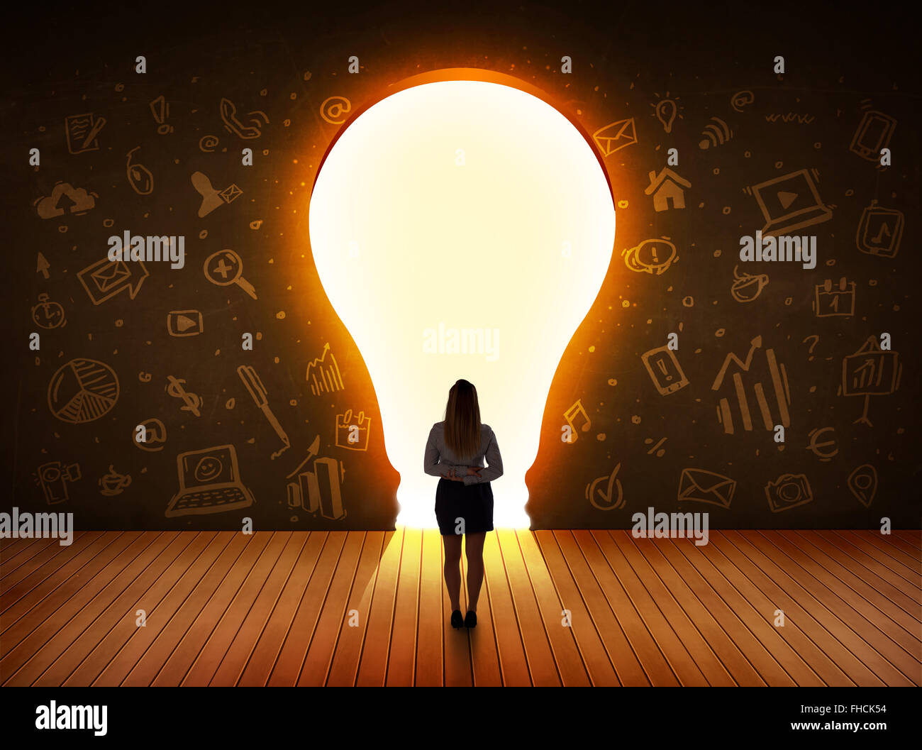 Business donna che guarda la luce brillante lampadina nella parete Foto Stock