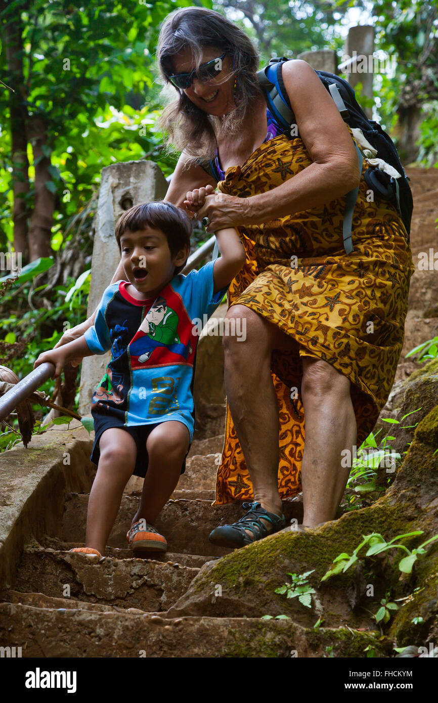 Nonna e nipote sul ripido sentiero verso il basso per il mi-Tu cascata sul Bolaven Plateau vicino a PAKSE - Southern, LAOS Foto Stock