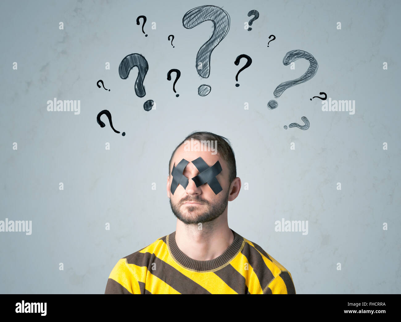 Giovane uomo con gli occhi incollati e punto interrogativo simboli Foto Stock