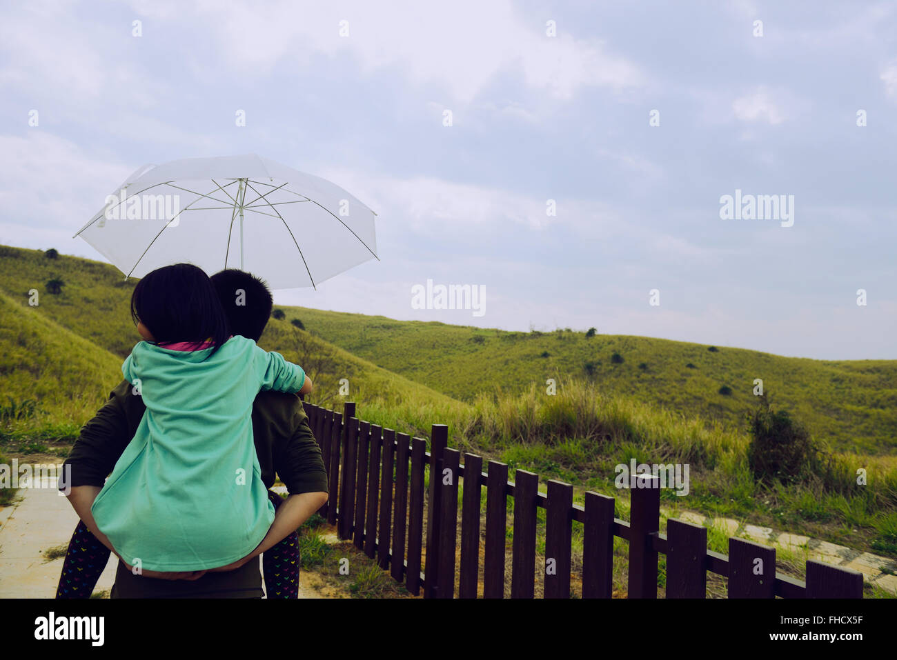 Figlia il Padre torna prendere ombrello ,ragazza sul padre prendere indietro ombrello,Padre da giovane figlia piggyback ride Foto Stock
