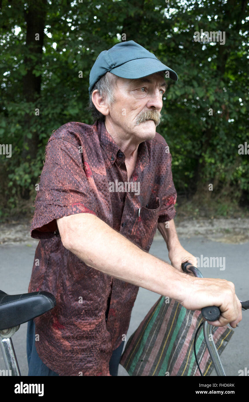 Polish gentleman età 70 che porta una borsa da shopping locale viaggio utilizza la bicicletta per il trasporto. Rzeczyca Polonia centrale Foto Stock