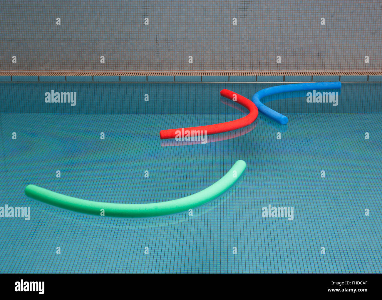 Aqua noodles galleggiante sull'acqua di piscina interna Foto Stock