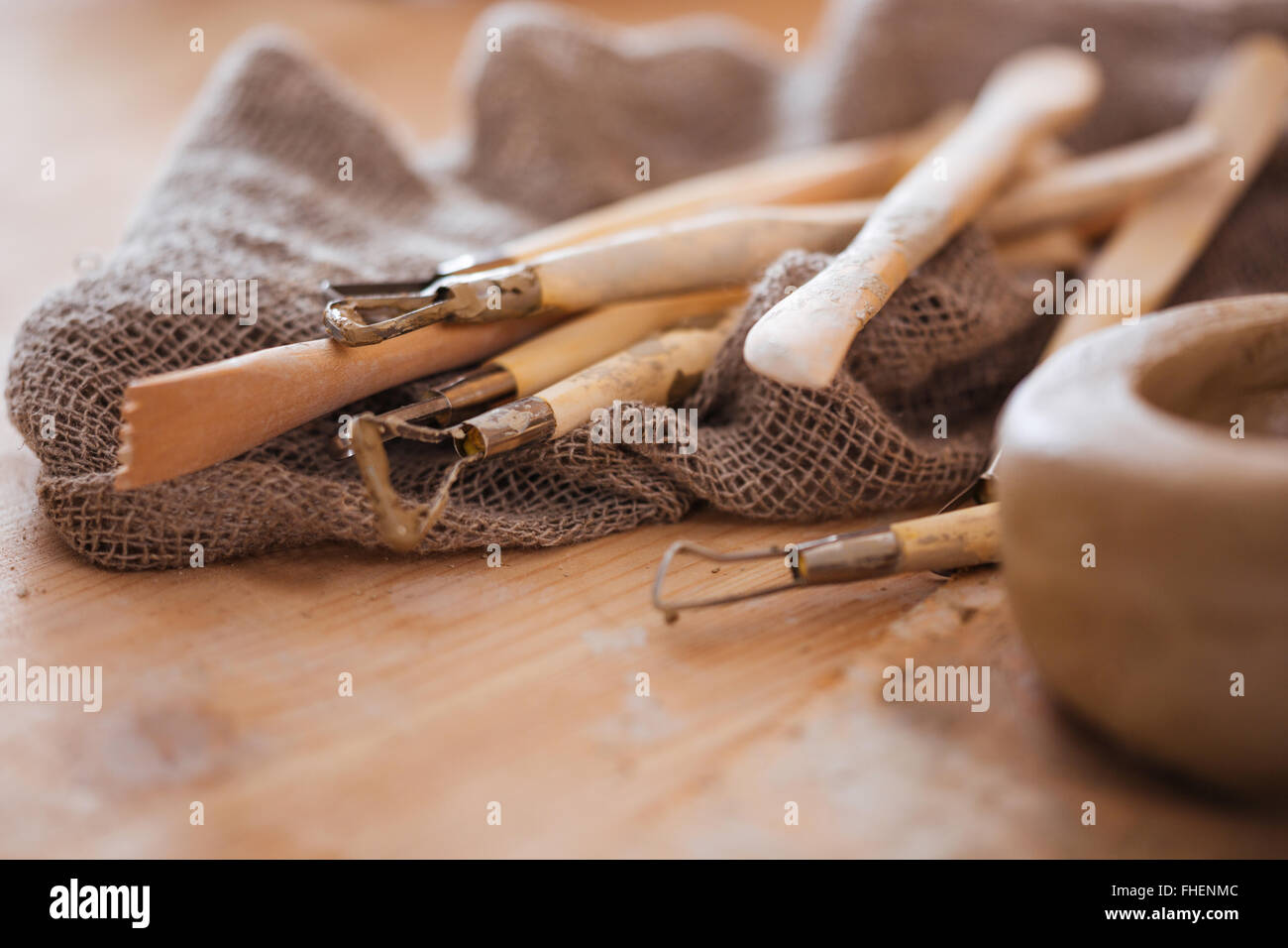 Set di sporco arte e artigianato scultura strumenti sul tavolo di legno nel laboratorio di ceramica Foto Stock