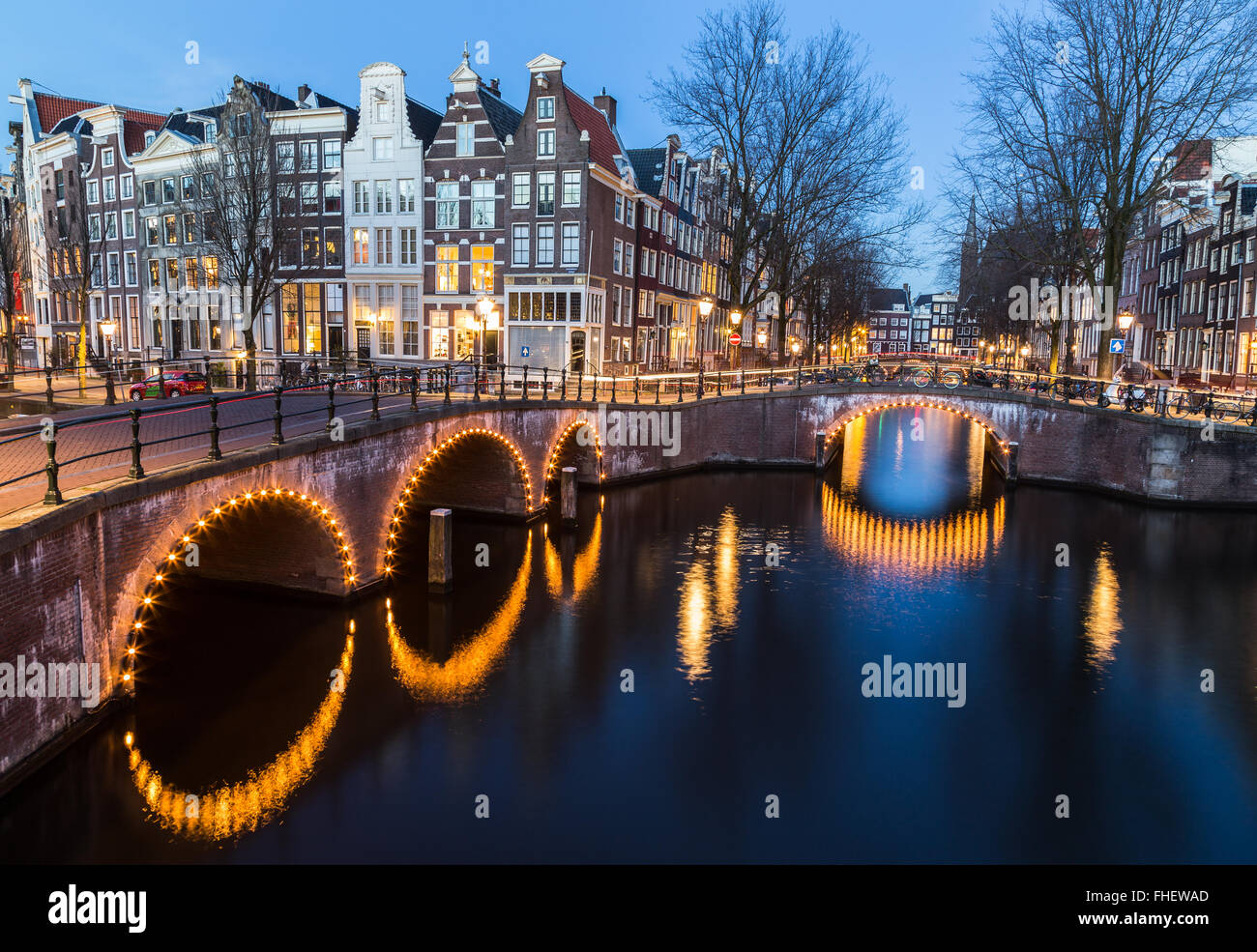 Una vista dei ponti a Leidsegracht e Keizersgracht intersezione dei canali di Amsterdam al crepuscolo. Le biciclette e gli edifici possono essere Foto Stock