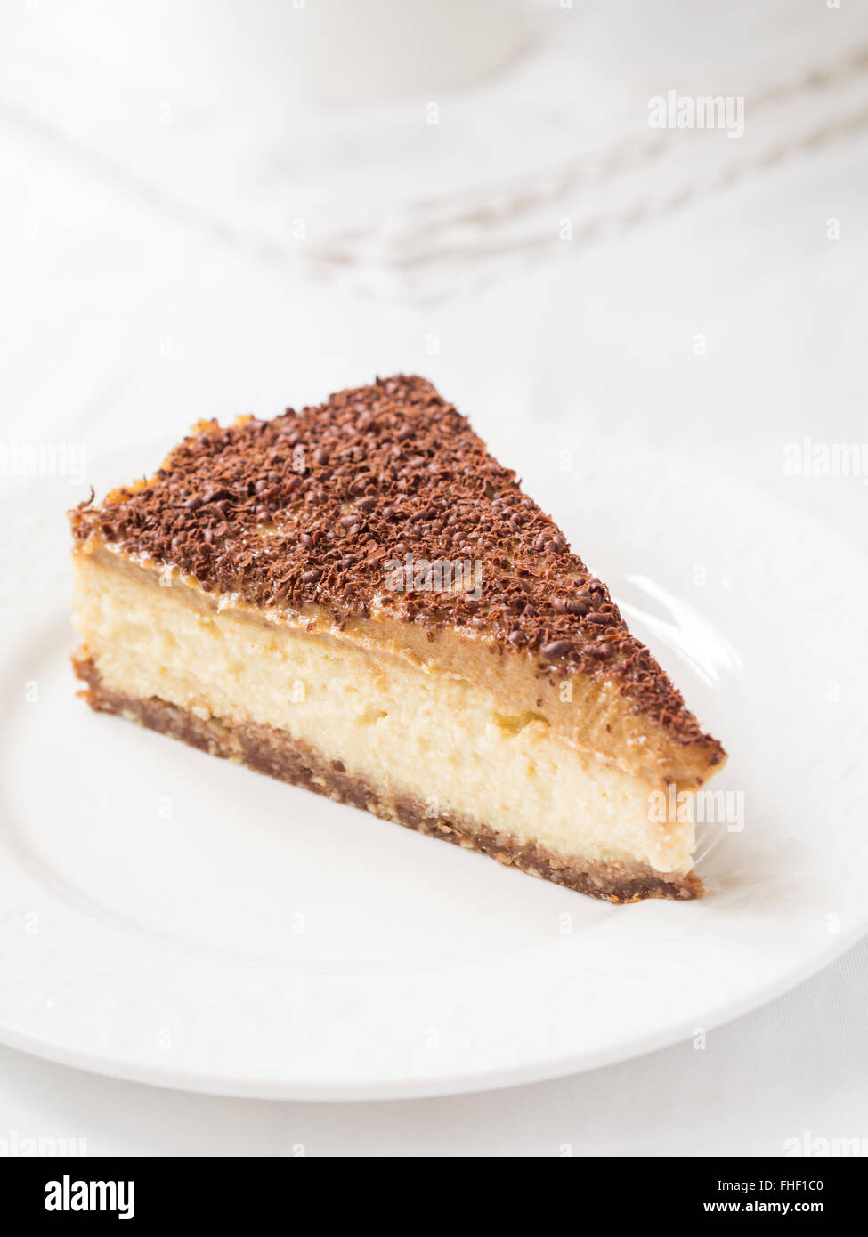 Fetta di miglio vegan cheesecake con caramello data su una placchetta dello sfondo. Foto Stock