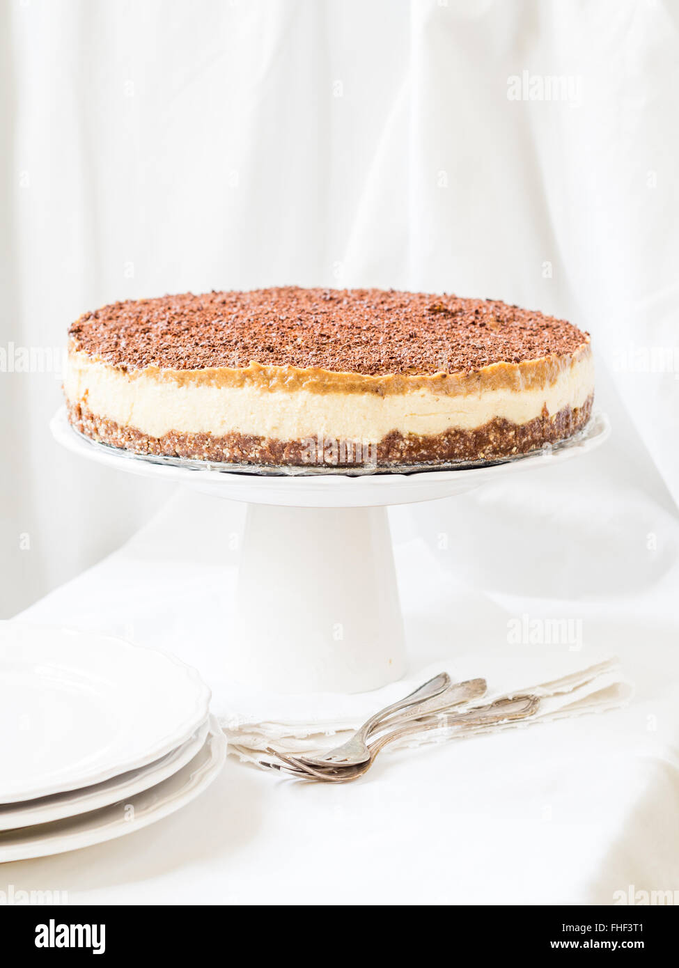 Tutto il miglio vegan cheesecake con caramello data su una placchetta dello sfondo. Foto Stock