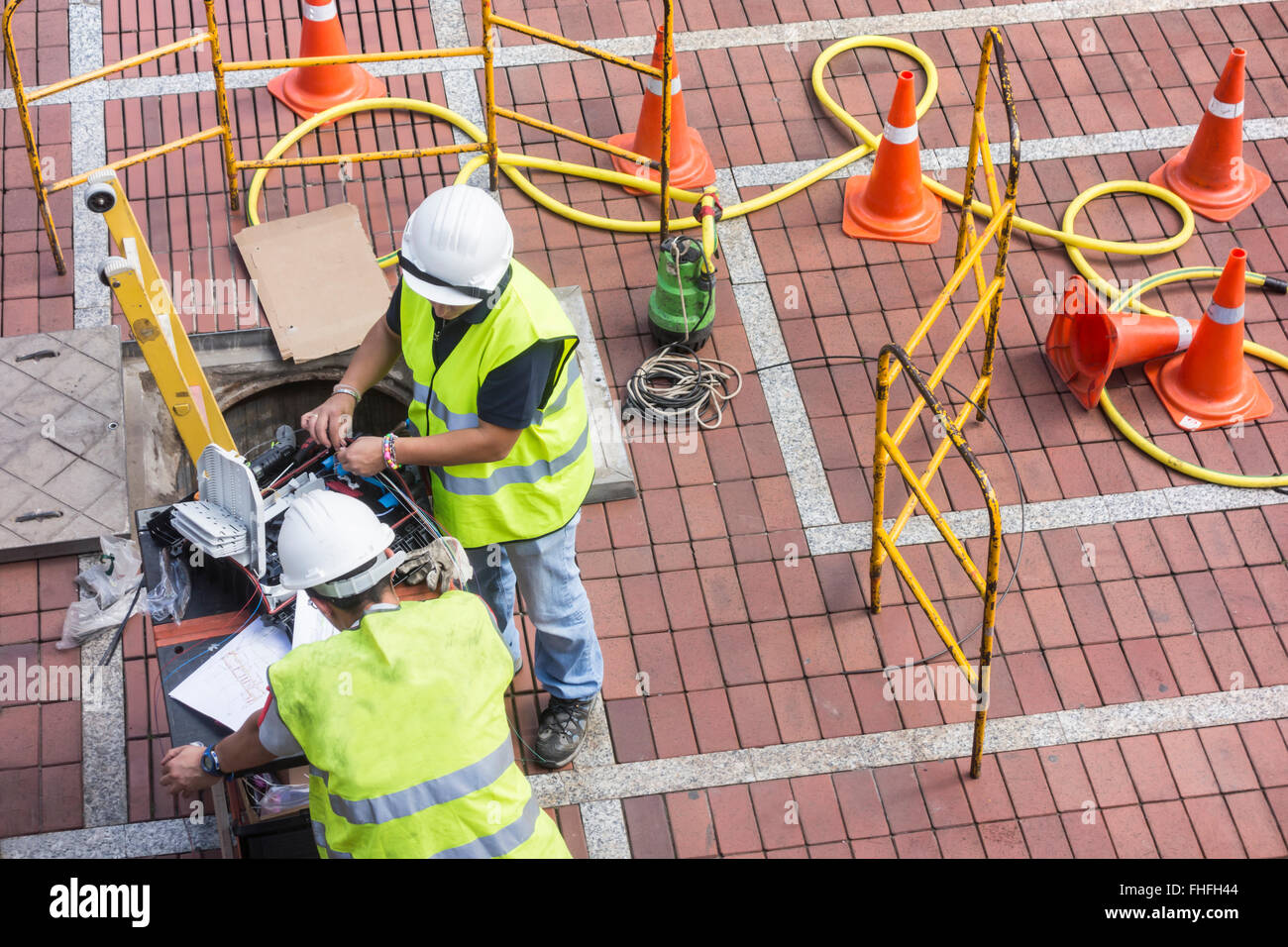 Gli ingegneri di telefono (maschio e femmina) installazione di cavi a fibre ottiche. Foto Stock