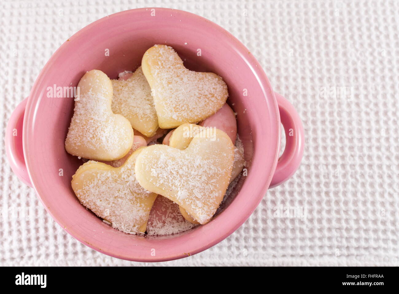 A forma di cuore biscotti in una ciotola rosa Foto Stock