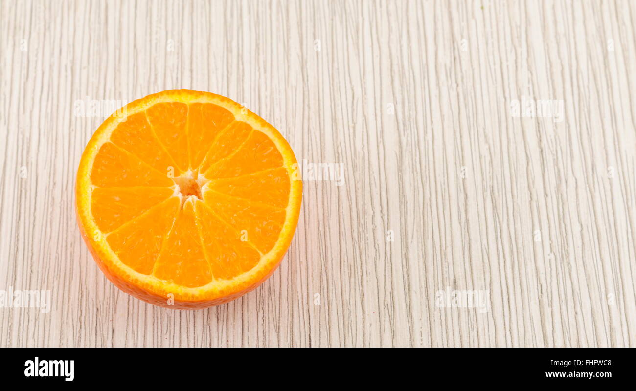 A metà di un arancione bianco sul tavolo di legno Foto Stock