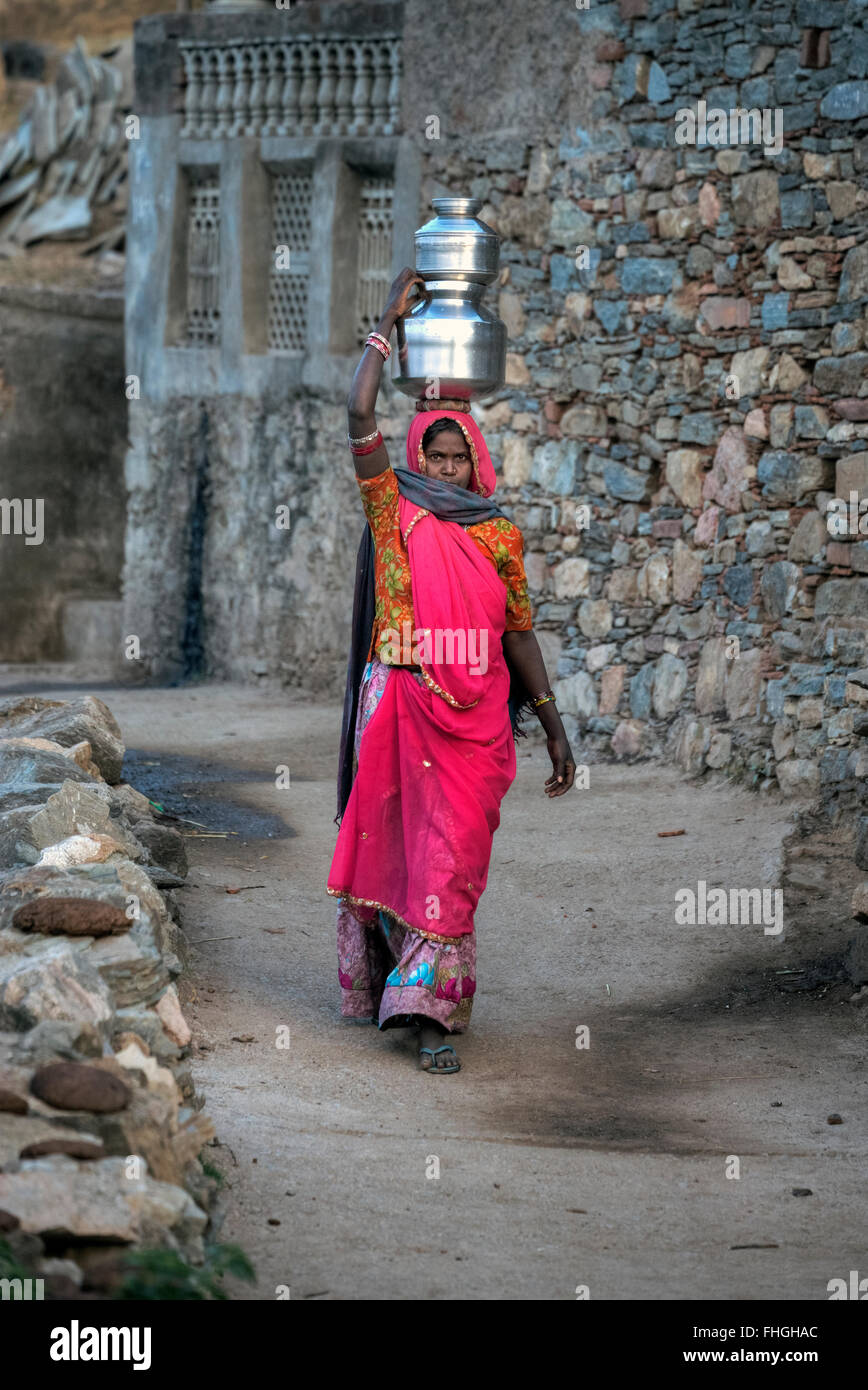 Donna che trasportano acqua sulla loro testa nelle zone rurali del Rajasthan, India Foto Stock