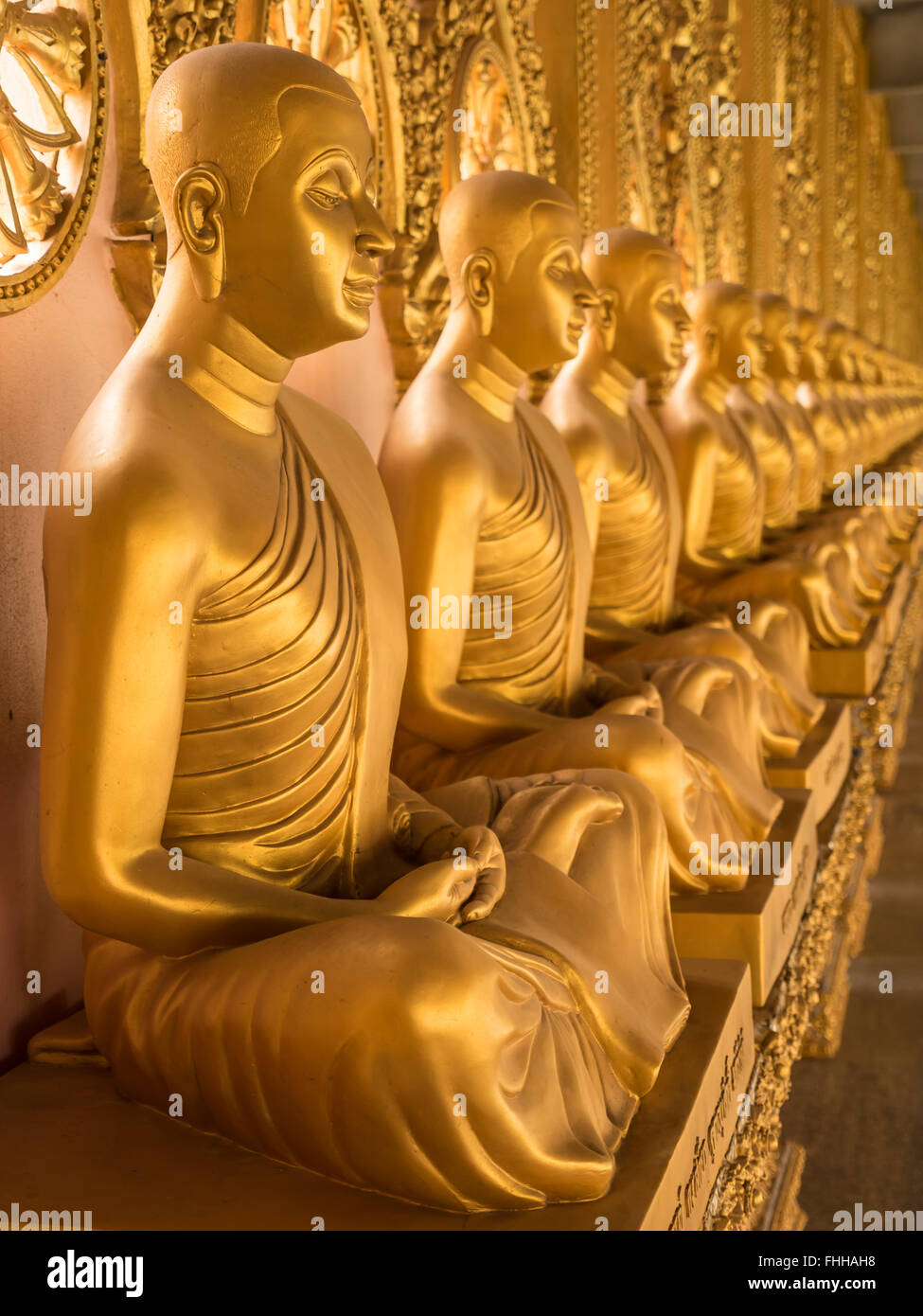Allineamento delle statue di Buddha nel tempio, Thailandia Foto Stock