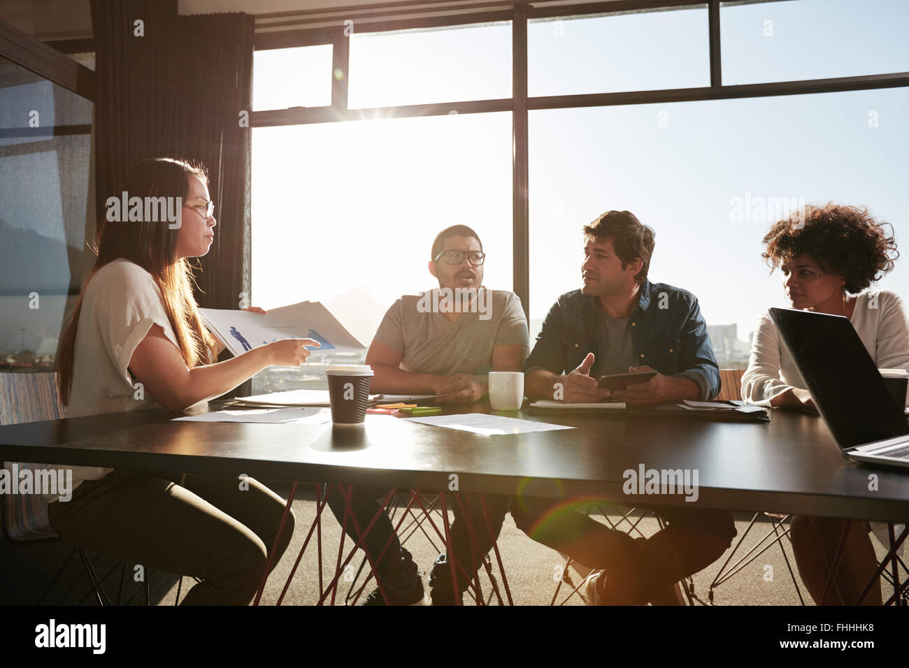 Giovane donna business consulting nuovi piani aziendali con i suoi colleghi. Le persone creative che discutere di documenti e di idee. Foto Stock