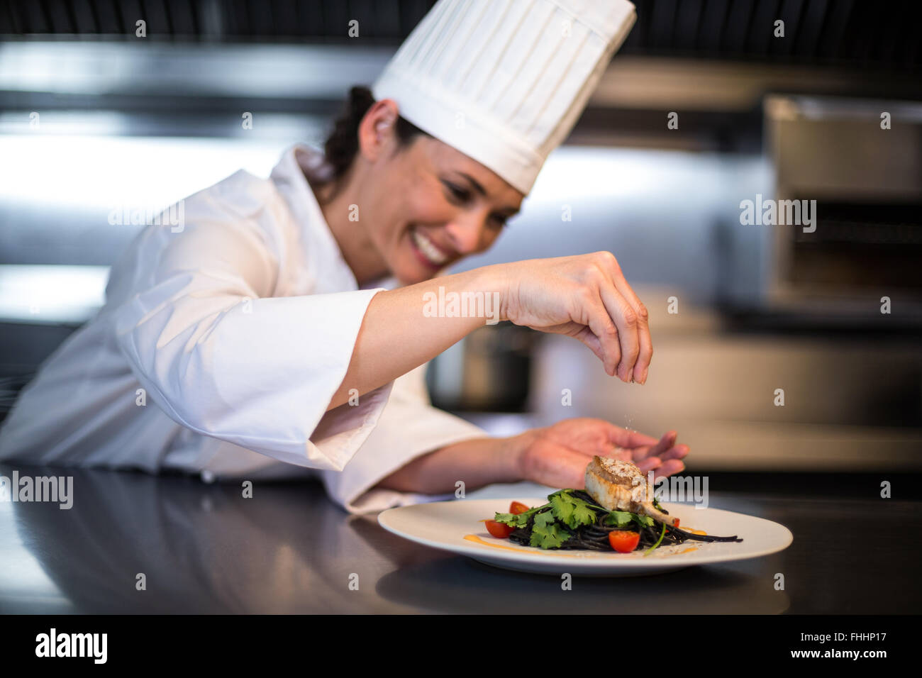 Lo chef felice la stagionatura il suo piatto Foto Stock