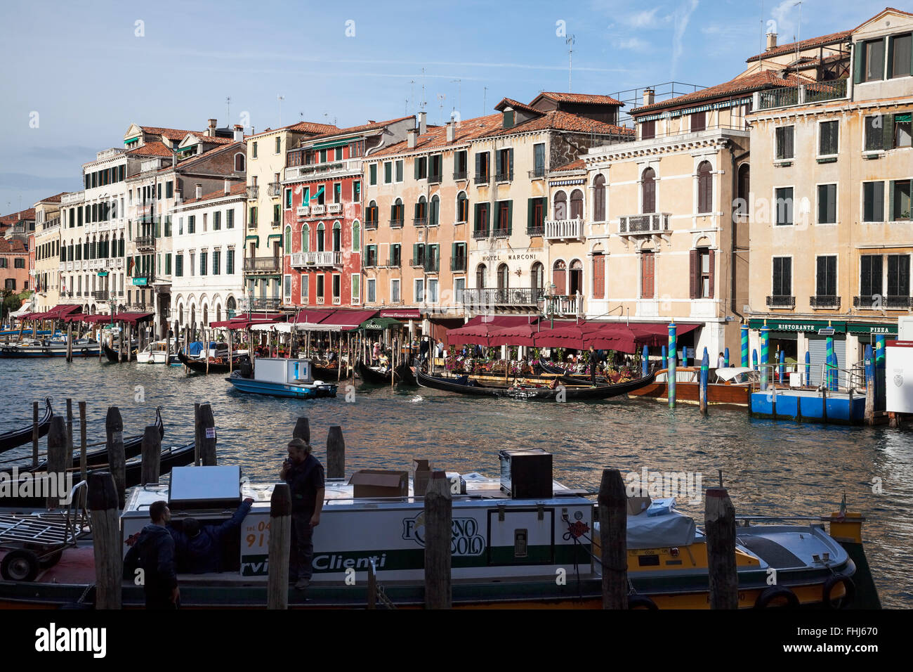 Soleggiato edifici e gondole lungo il Canal Grande di Venezia con servizio di barche in primo piano Foto Stock