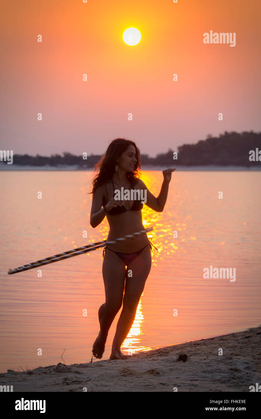 Ballerina di Hula stagliano contro il sole di setting Foto Stock