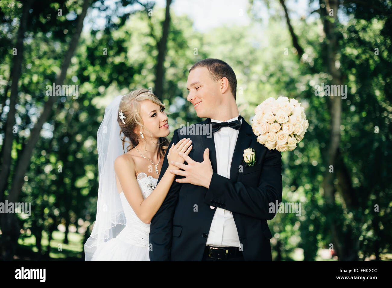 Sposa e lo sposo all'aperto su un giorno di nozze in posizione di parcheggio Foto Stock