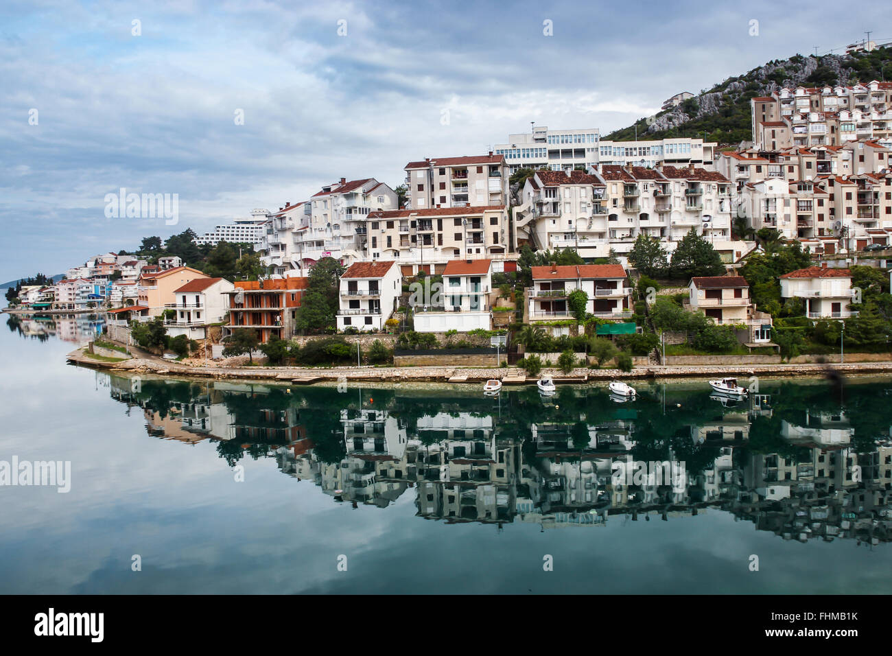 La bella riflessione di un piccolo villaggio in Bosnia Erzegovina nel silenzio della baia di mattina. Il villaggio era ancora dormendo. Foto Stock