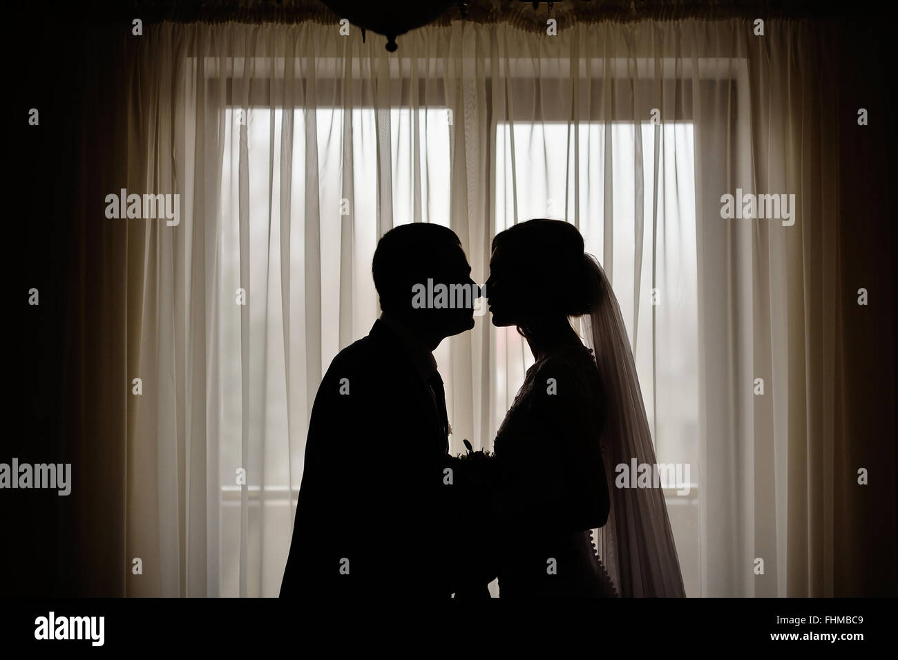 Sagome dello sposo e della sposa sullo sfondo di una finestra Foto Stock