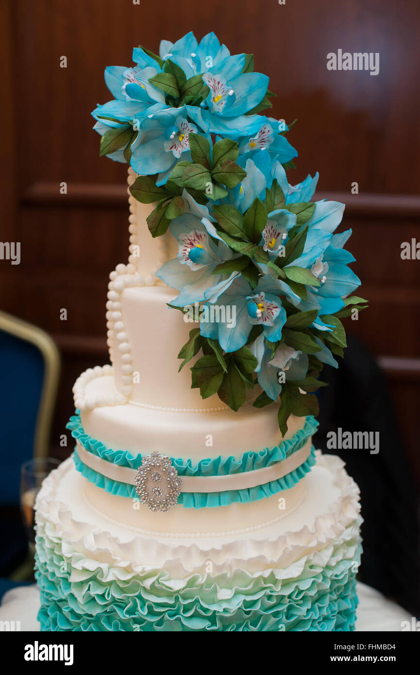 Bellissimo il turchese su tre livelli, torta di nozze con fiori sulla parte superiore Foto Stock