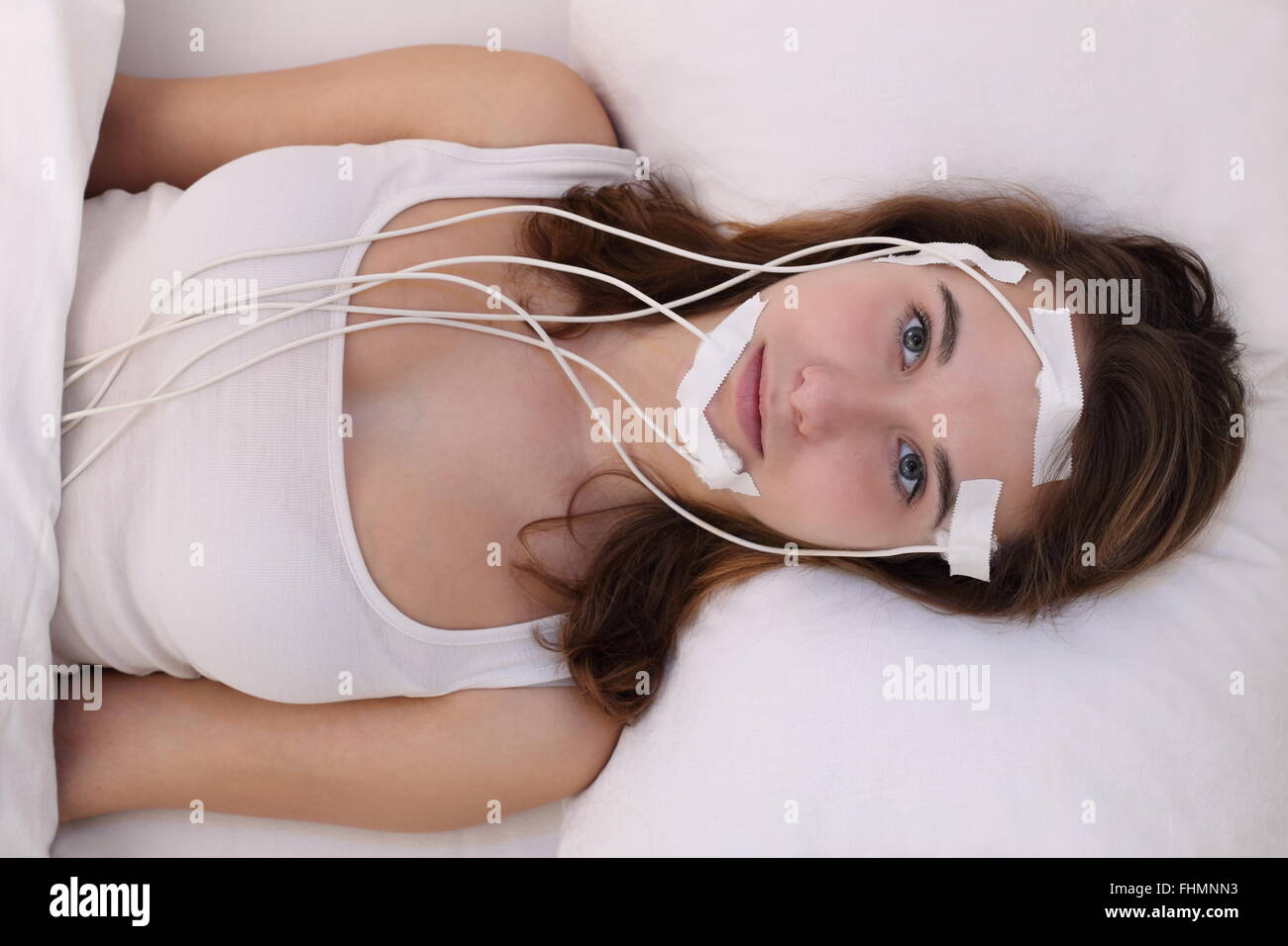 Una giovane donna masuring brainwaves eg in un laboratorio del sonno Foto Stock