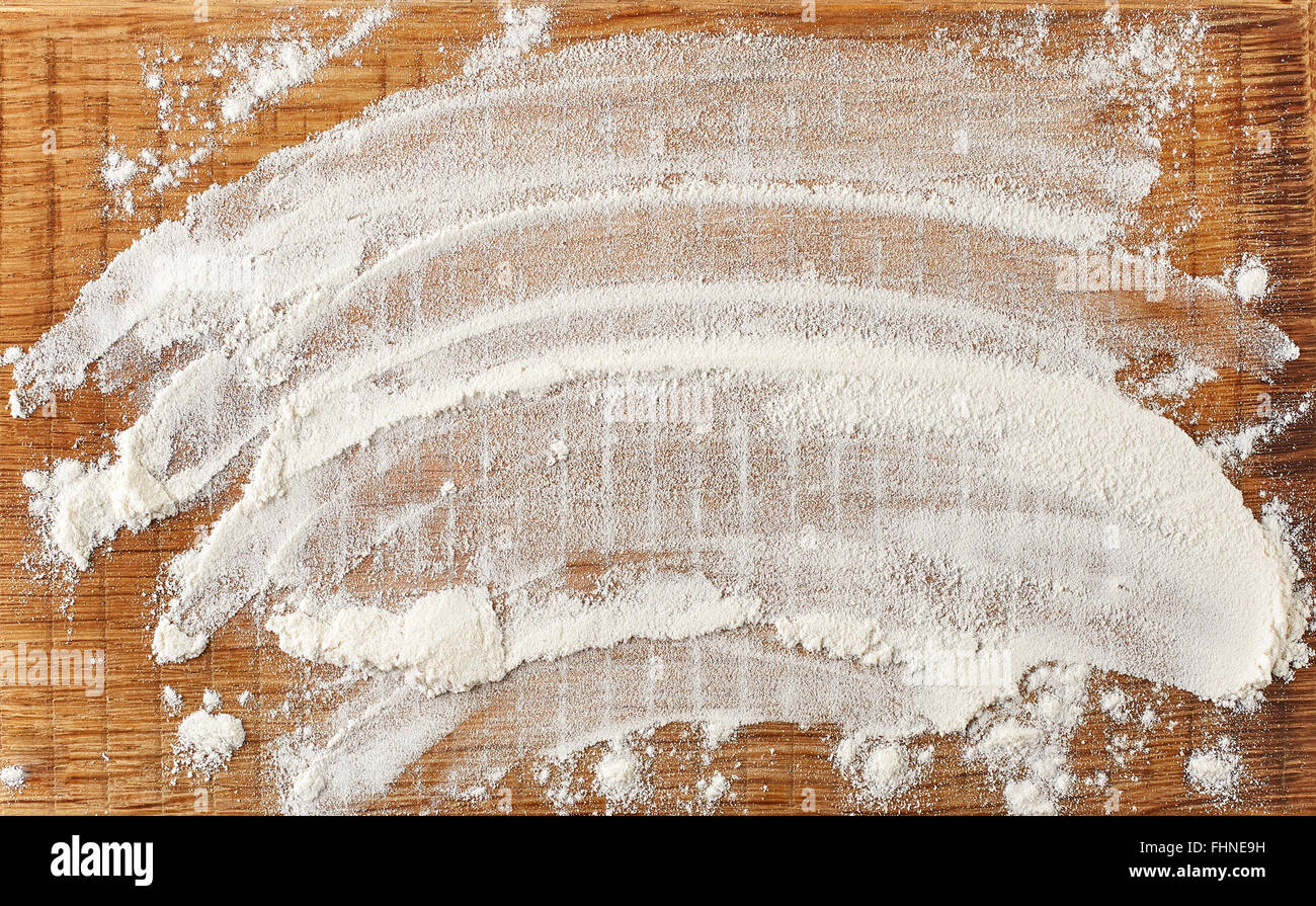 Farina bianca sul tagliere di legno, vista dall'alto Foto Stock
