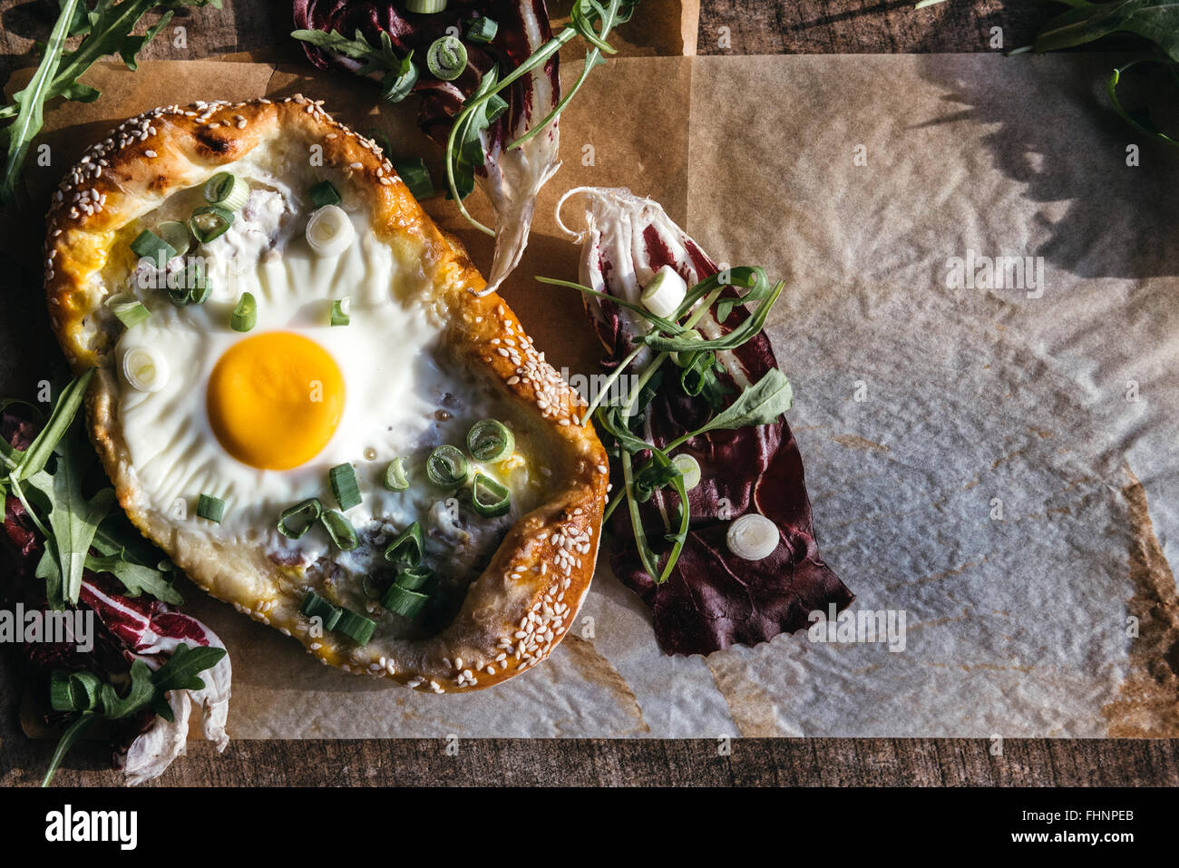 Servita mini pizza con uovo fritto su sfondo di legno con uno spazio vuoto Foto Stock