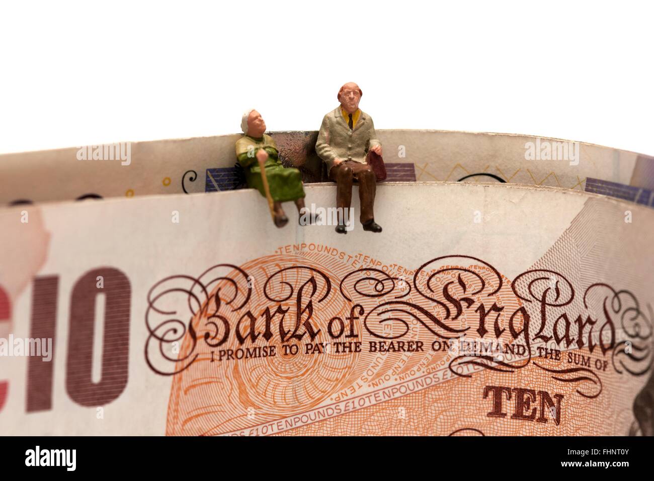 Miniatura due anziani seduti sulla sommità del British dieci e venti pound note Foto Stock