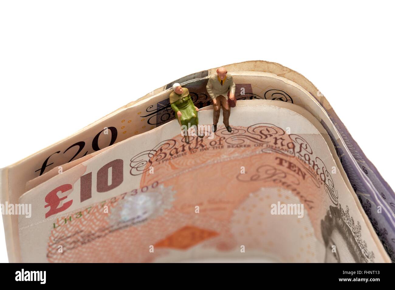 Miniatura due anziani seduti sulla sommità del British dieci e venti pound note Foto Stock