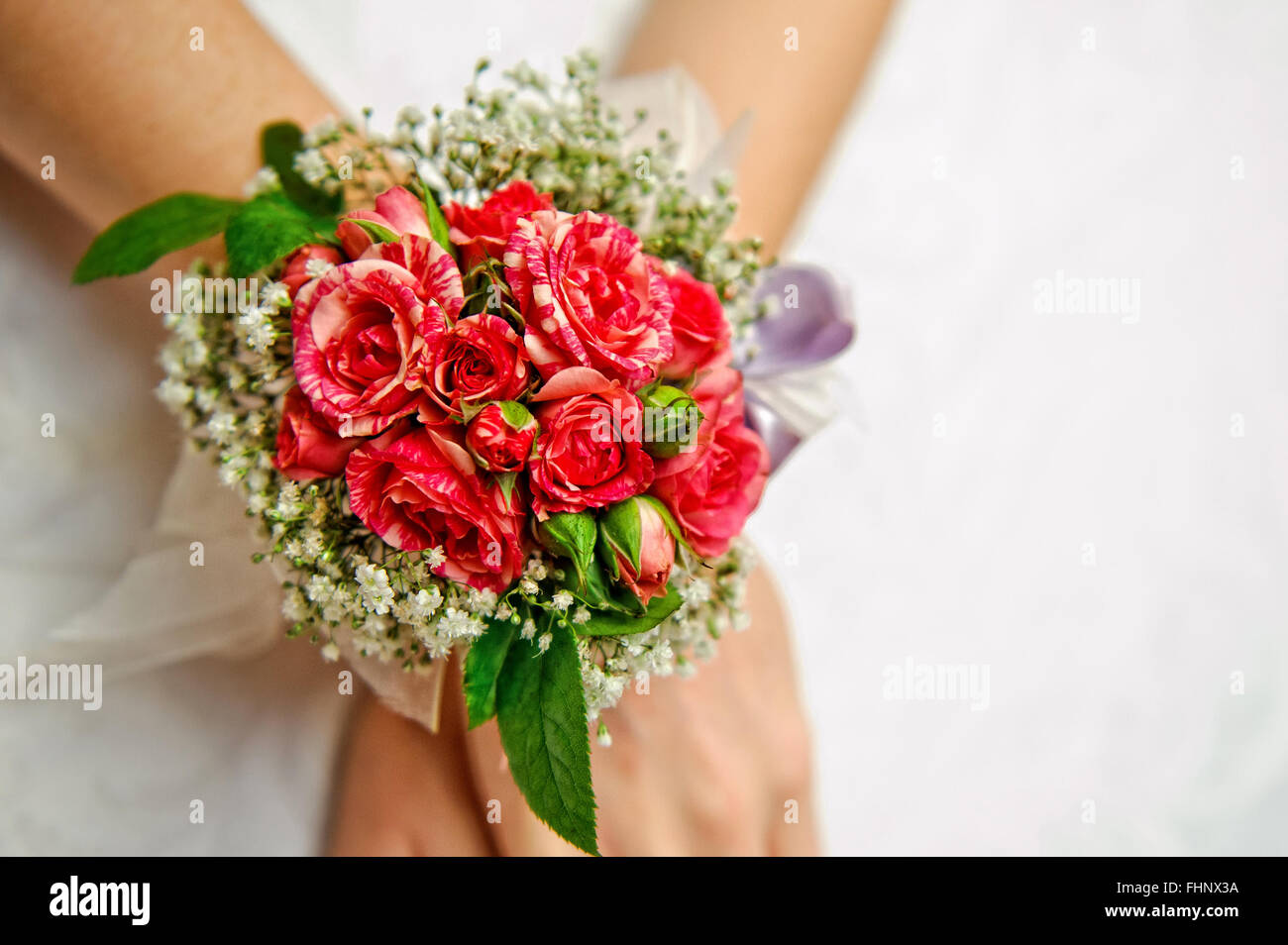 Damigella nel lusso abito da sposa porta ai delicati boutonniere con rose Foto Stock