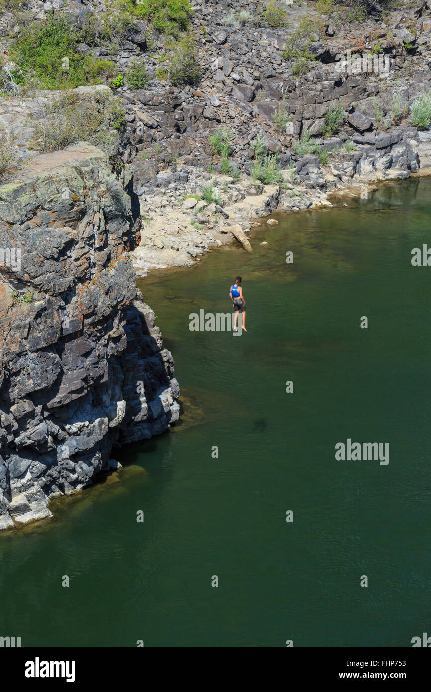 Persona che salta da una scogliera nel fiume Clark Fork in alberton gorge vicino Alberton, montana Foto Stock