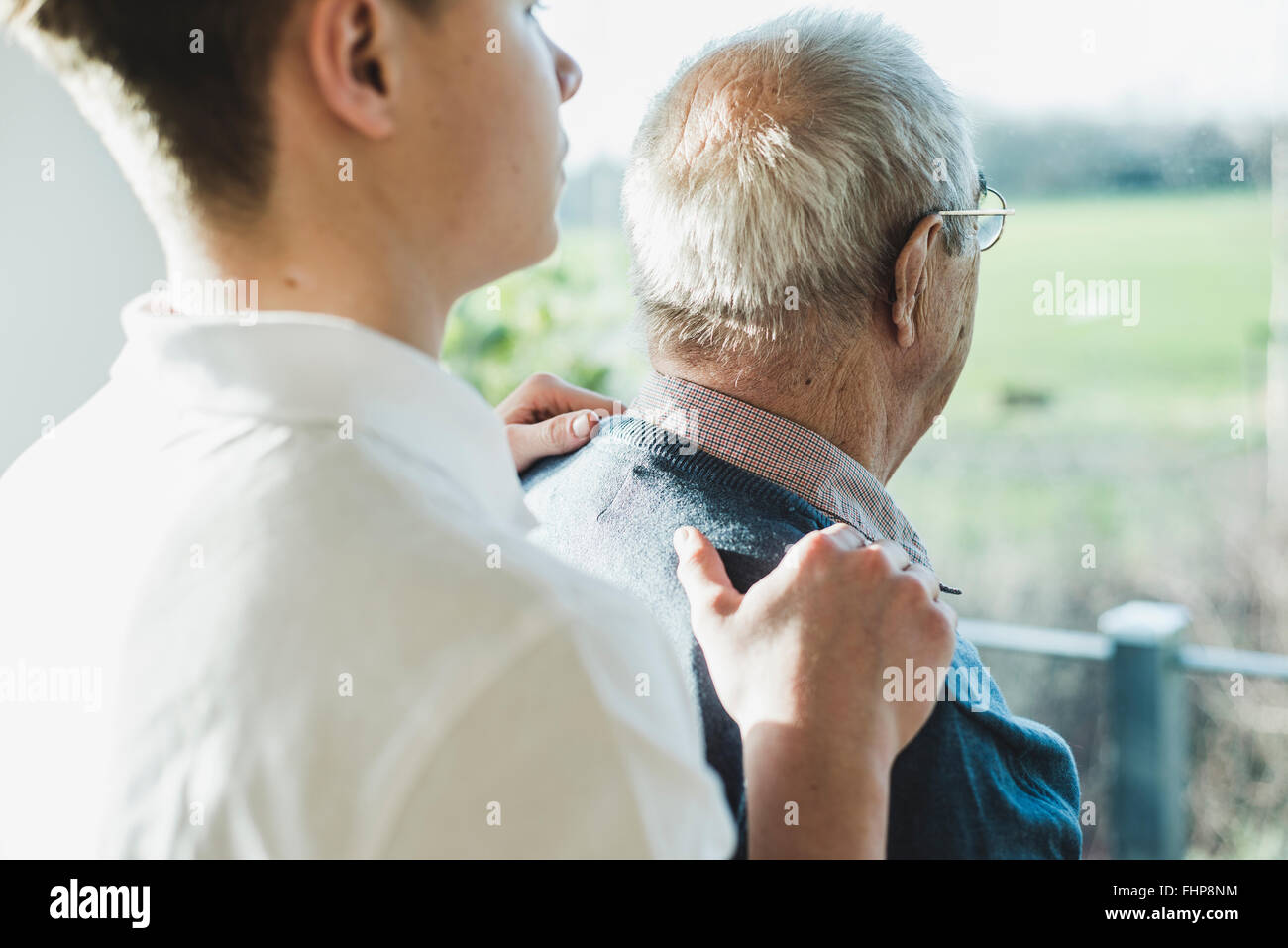 Vista posteriore del senior l uomo e la sua infermiera geriatrica Foto Stock