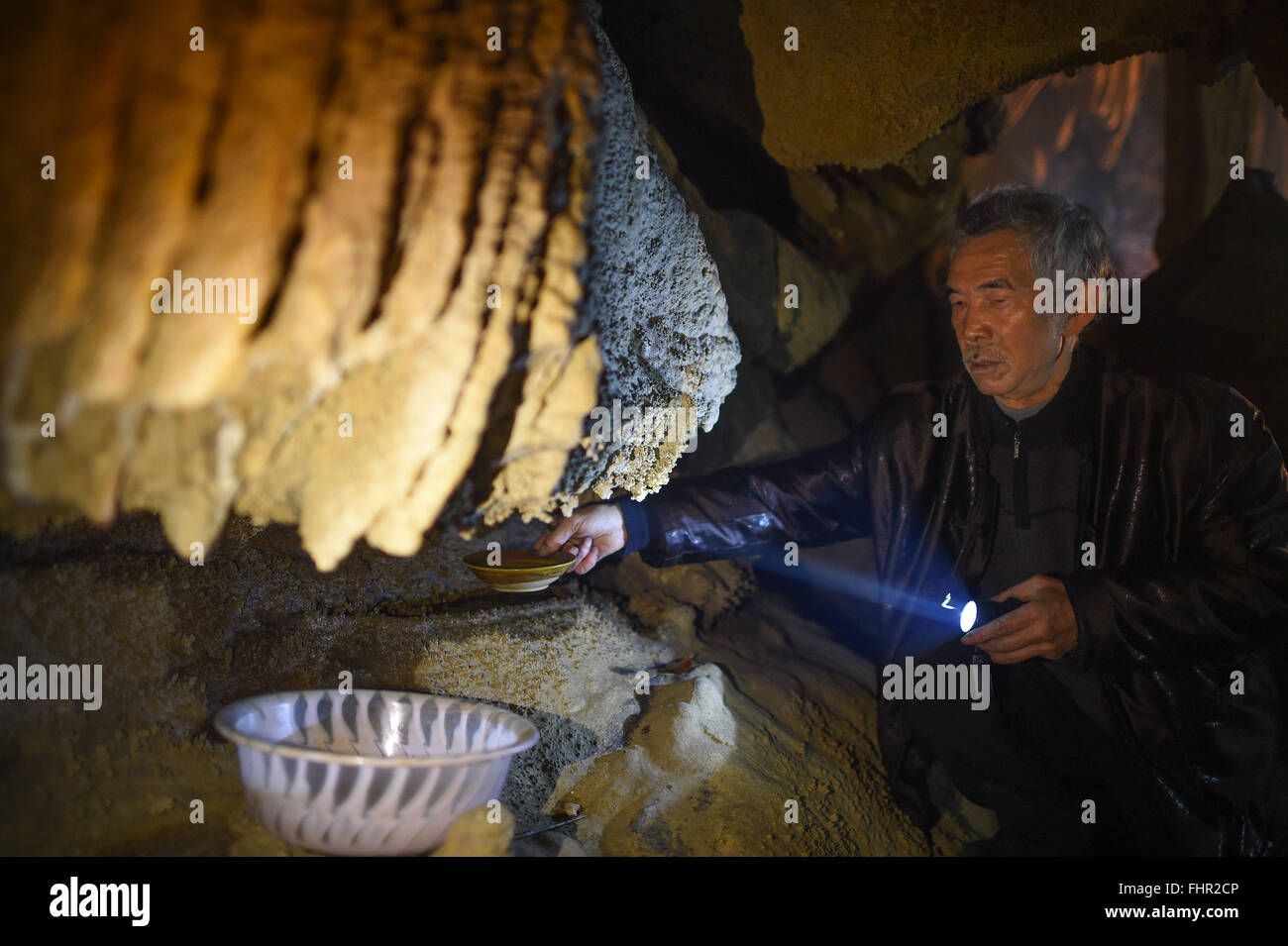 (160226) -- YUQING, Feb 26, 2016 (Xinhua) -- canzone Chuanzhong riceve acqua nella sua grotta studio in Yuqing County, a sud-ovest della Cina di Guizhou, Feb 26, 2016. Il sig. Song, un 67-anno-vecchio pittore, impostare la sua arte studio in una naturale grotta carsica di circa 60 metri quadrati, dove viveva in per quasi trenta anni fino allo scorso anno ma ancora venuto a vernice e goduto di una buona volta di tutti i giorni. (Xinhua/Liu Xu) (Cxy) Foto Stock