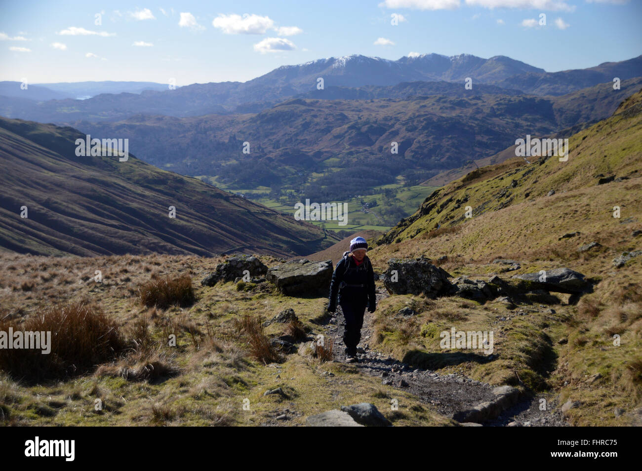 Lone Lady dirigendosi verso Grisedale Hause su Wainwrights Coast to Coast Path dal timone Gill sopra la valle di Grasmere Foto Stock