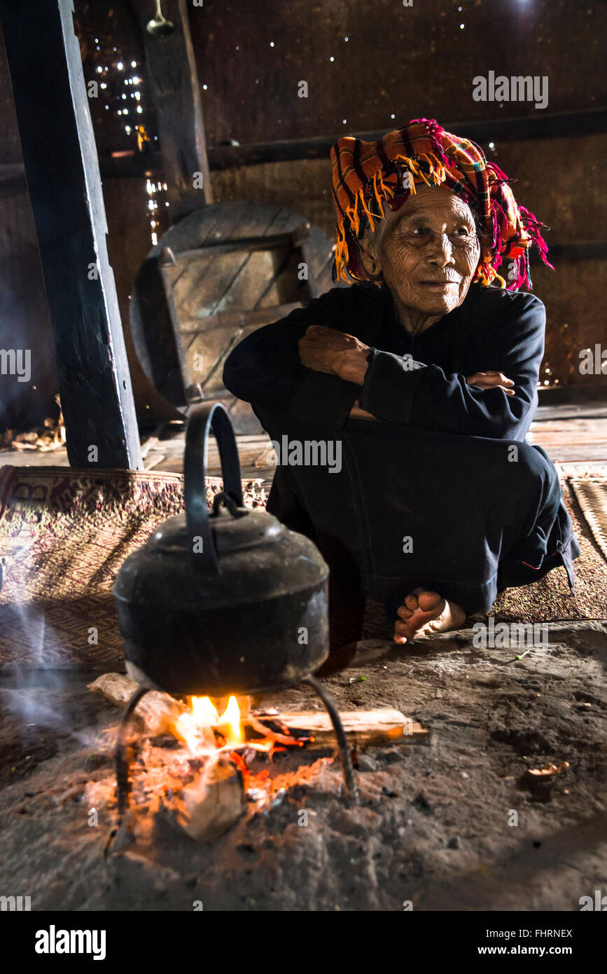 Vecchia donna in cucina, bollitore su un fuoco aperto posto nella lodge, tribù di montagna o mountain people Pa-O O O Pa-Oh Pao o Foto Stock