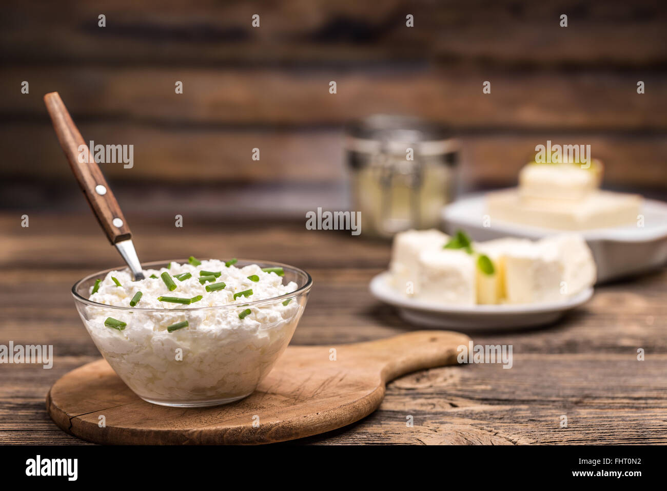 Cottage fresco formaggio con erba cipollina nella ciotola di vetro, cibo sano Foto Stock