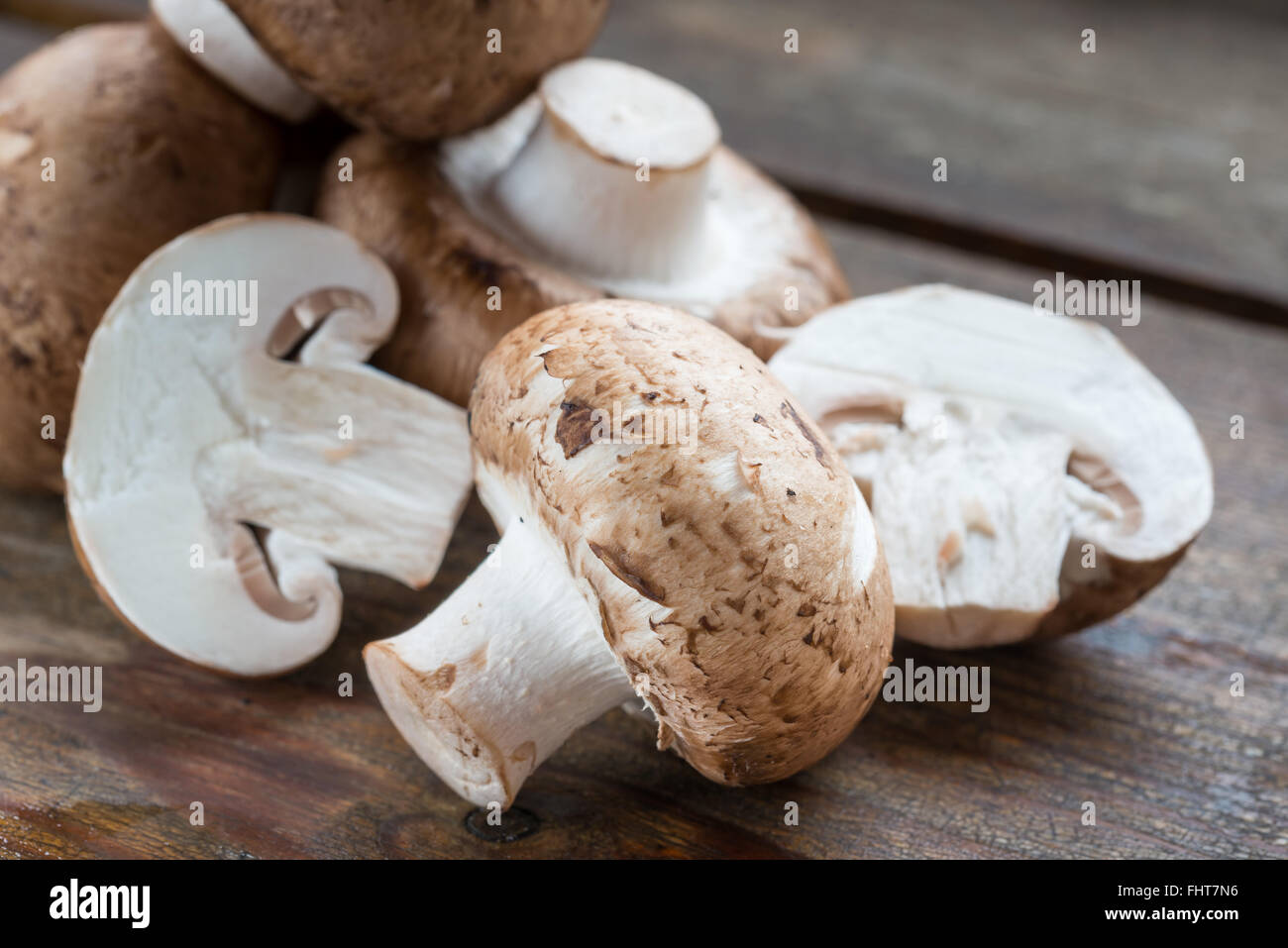 Primo piano della fresca bruna funghi champignon, Agaricus bisporus, su legno Foto Stock