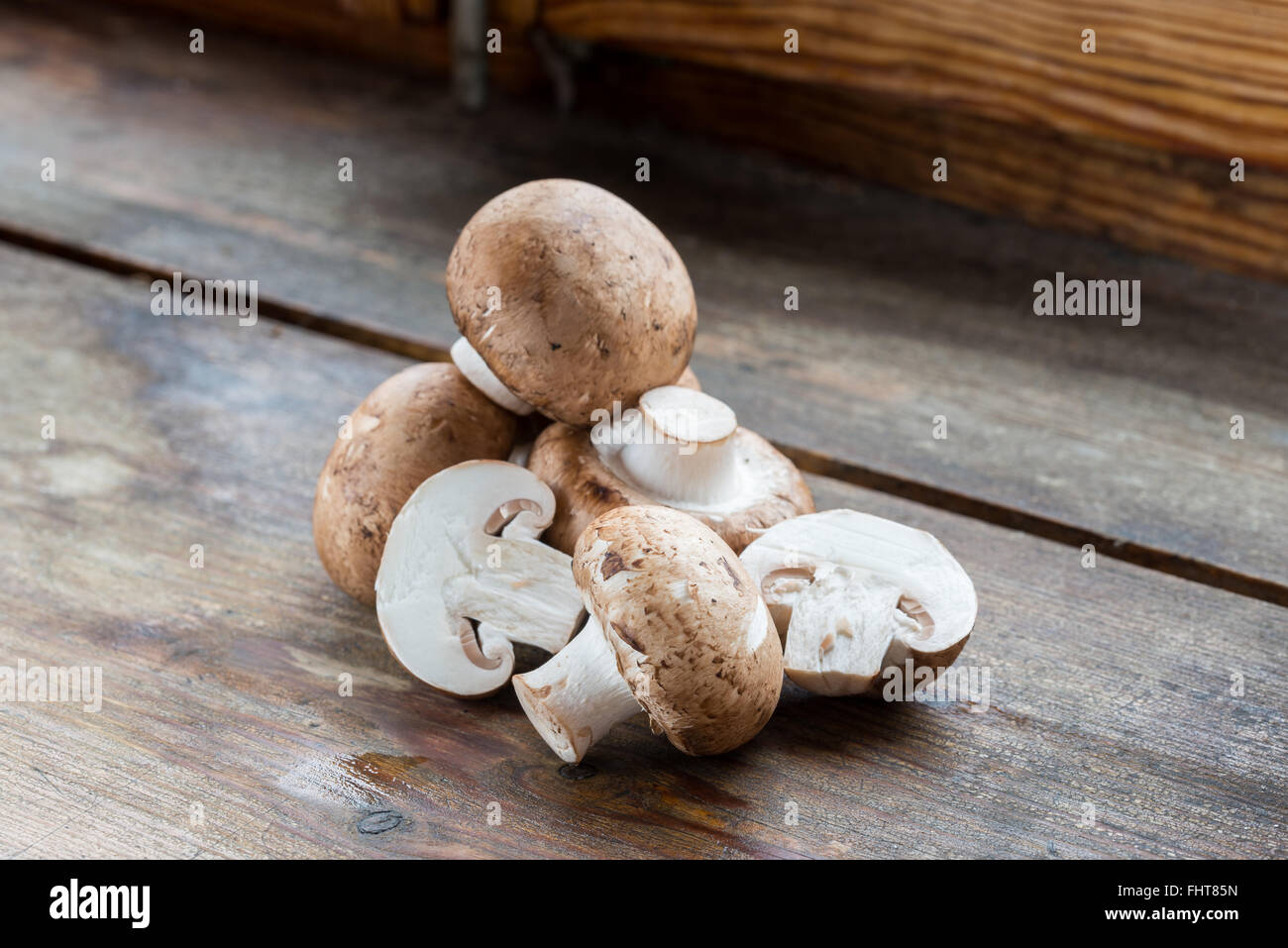 Fresca bruna funghi champignon, Agaricus bisporus, su legno Foto Stock