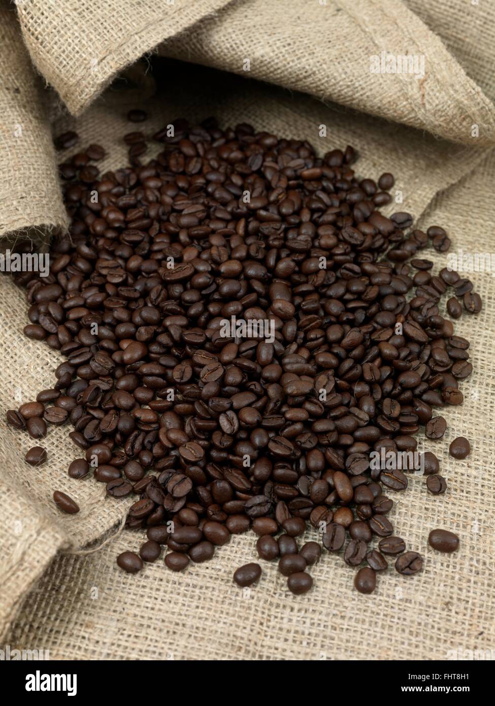 Il caffè fresco fagioli su marrone hessian sacchi Foto Stock