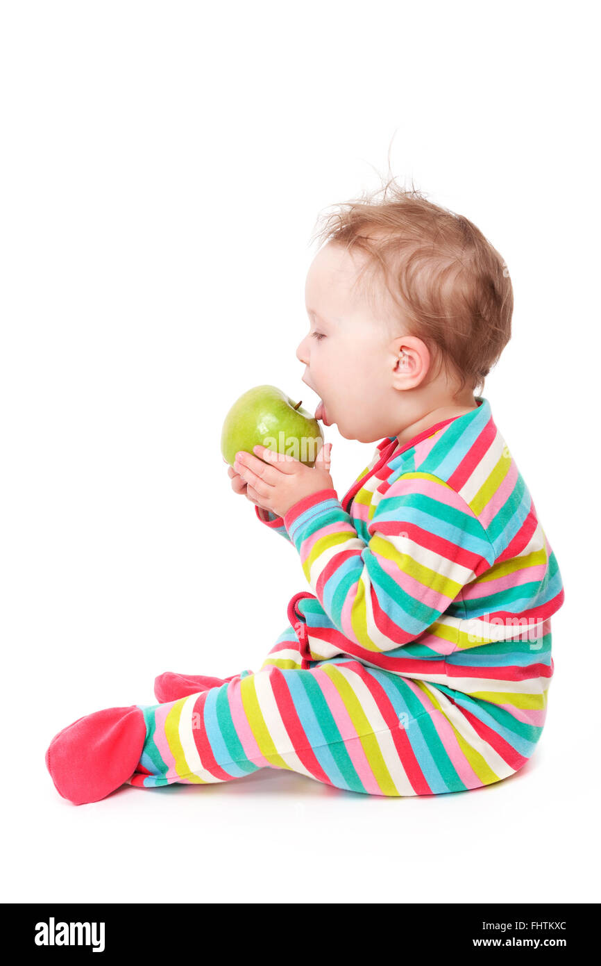 Baby girl eating apple isolato su bianco. Foto Stock