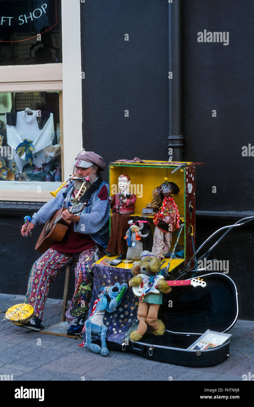 One man band busker musicista di strada a Kinsale con un serraglio di bambole e peluche marionette. Kinsale, County Cork, Irlanda. 1995. Scansione da 35mm trasparenza. Foto Stock