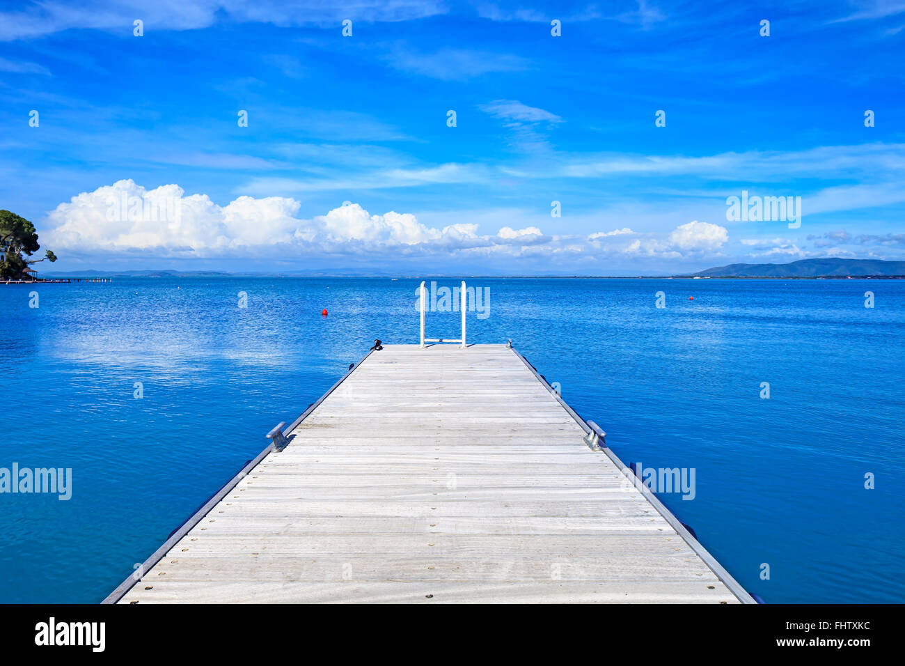 Il molo di legno o molo su un blu oceano e cielo chiaro. Bay beach in Monte Argentario, Porto Santo Stefano, Toscana, Italia Foto Stock