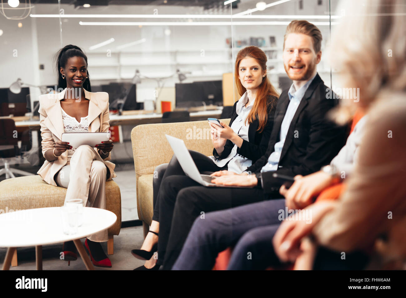 La gente di affari la conversazione con la tecnologia a portata di mano. Scambio di idee nuove e di brainstorming tra colleghi Foto Stock