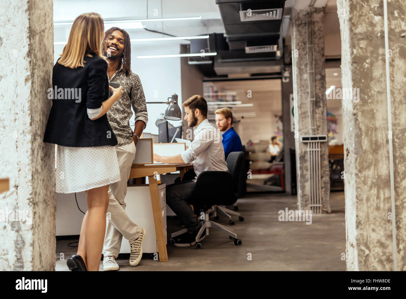 Colleghi di lavoro parlando in ufficio e sorridente Foto Stock