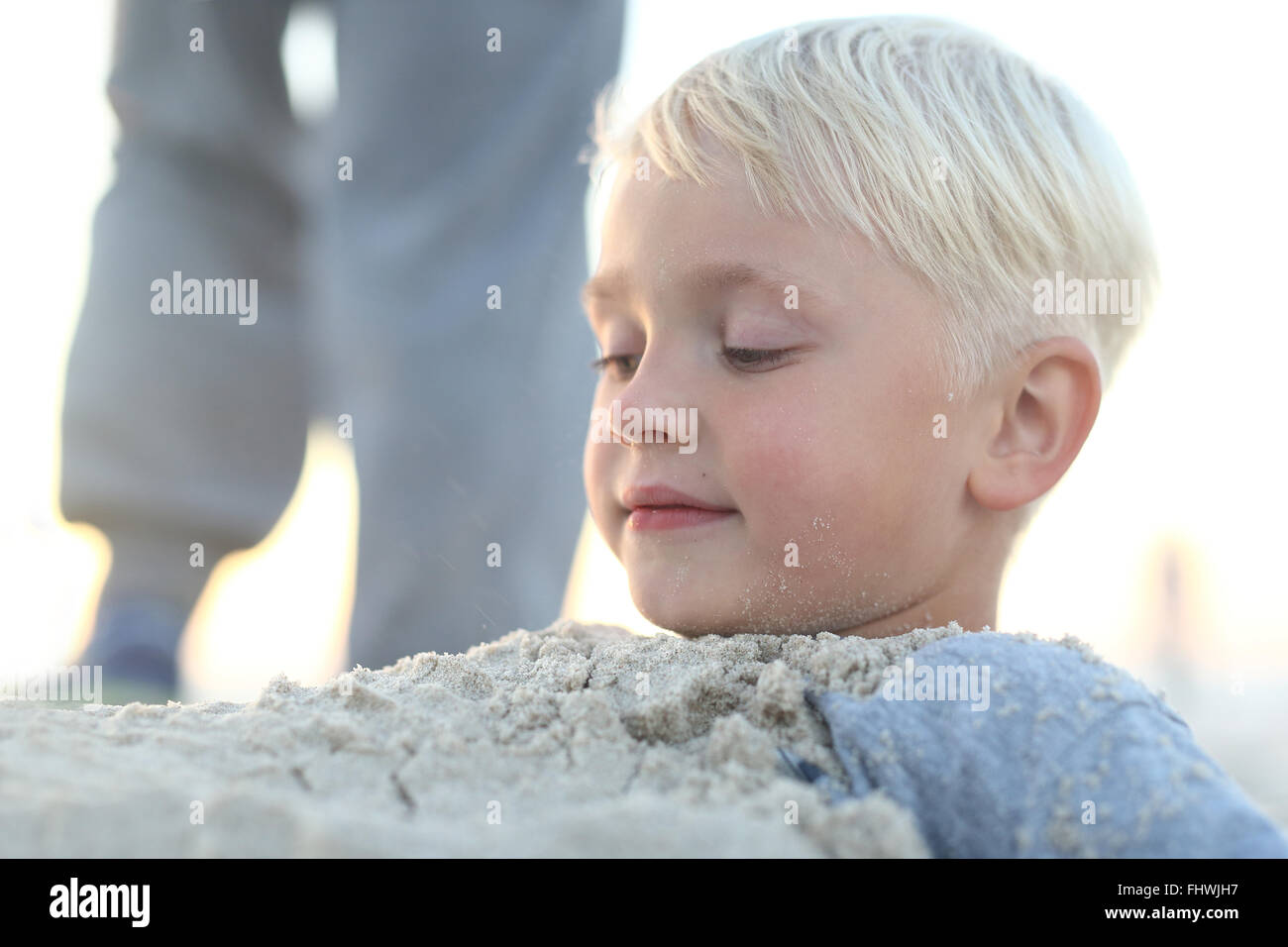 Divertimento nella sabbia sulla spiaggia . Bambino sulla spiaggia . Allegro ragazzino giocando nella sabbia sulla spiaggia. Divertimento in spiaggia Foto Stock